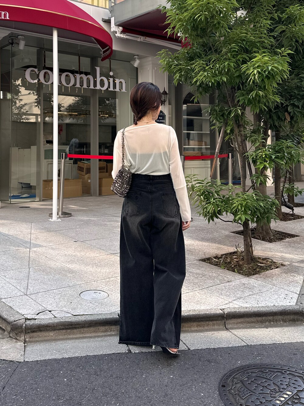 ホワイト系のTシャツ/カットソー、ブラック系のデニムパンツ、ブラック系のバッグを着用したレディースの夏コーディネートの5枚目の写真