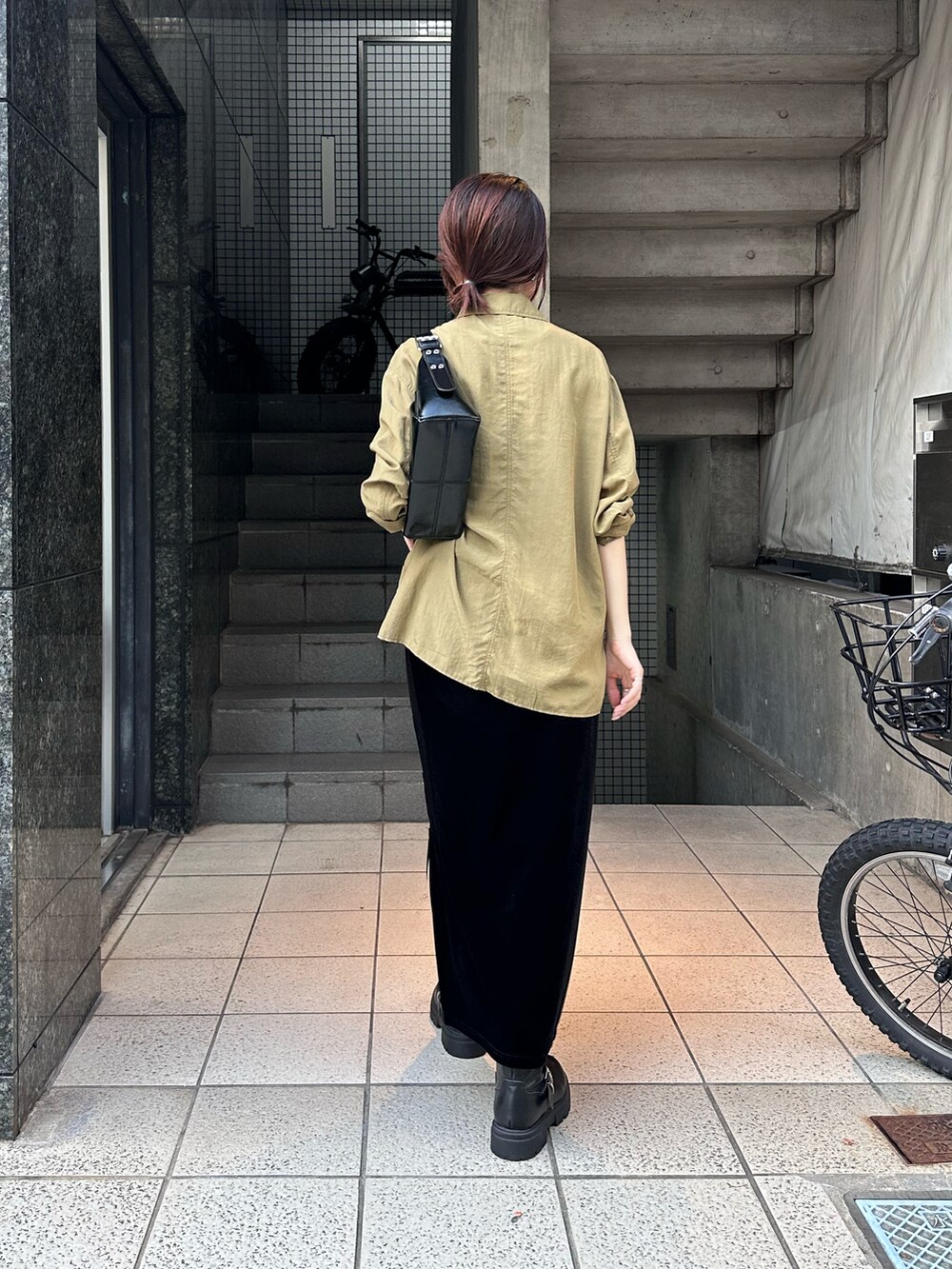 グリーン系のシャツ/ブラウス、ブラック系のスカート、ブラック系のバッグを着用したレディースの秋コーディネートの2枚目の写真