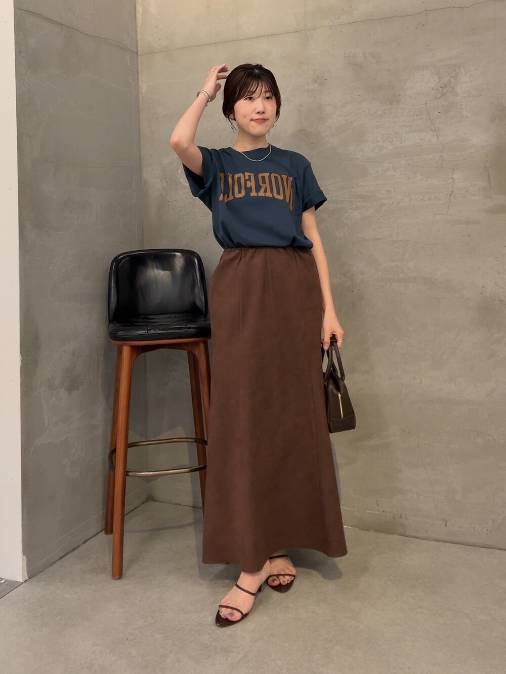 ブルー系のTシャツ/カットソー、ブラウン系のスカート、ブラウン系のショルダーバッグを着用したレディースの夏コーディネートの5枚目の写真