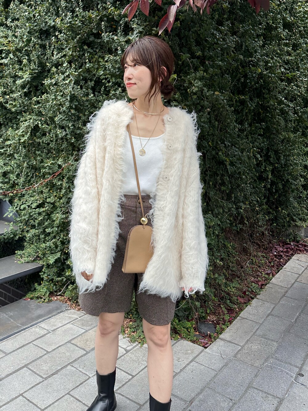 ホワイト系のカーディガン/ボレロ、ブラウン系のその他パンツ、ゴールド系のチョーカーを着用したレディースの秋コーディネートの2枚目の写真