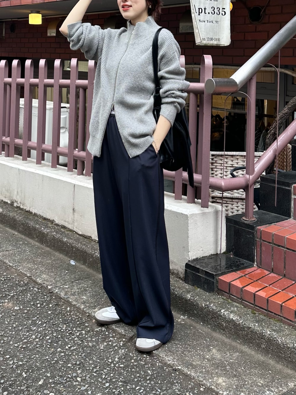 グレー系のカーディガン/ボレロ、ブルー系のスラックス、ブラック系のショルダーバッグを着用したレディースの秋コーディネートの2枚目の写真
