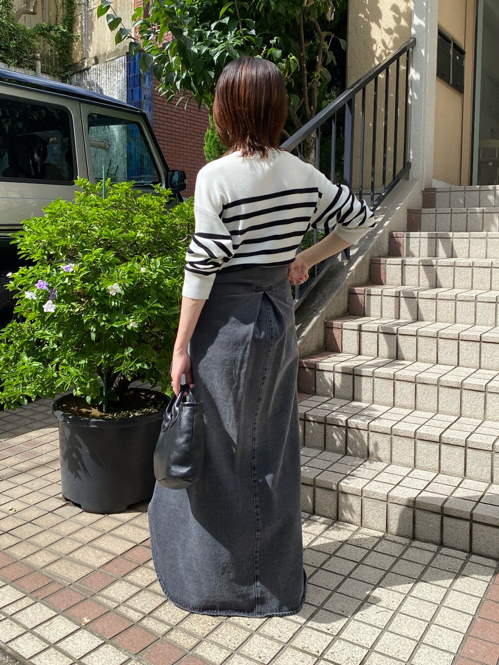 ホワイト系のニット/セーター、ブラック系のシャツワンピース、ブラック系のブーツを着用したレディースの夏コーディネートの3枚目の写真