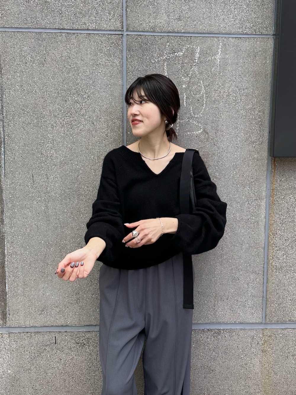 ブラック系のニット/セーター、ブルー系のスラックスを着用したレディースの秋コーディネートの3枚目の写真