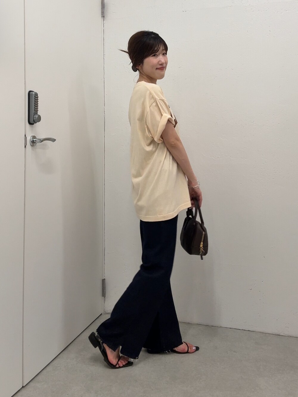 ベージュ系のTシャツ/カットソー、ブルー系のデニムパンツ、ブラウン系のショルダーバッグを着用したレディースの夏コーディネートの4枚目の写真