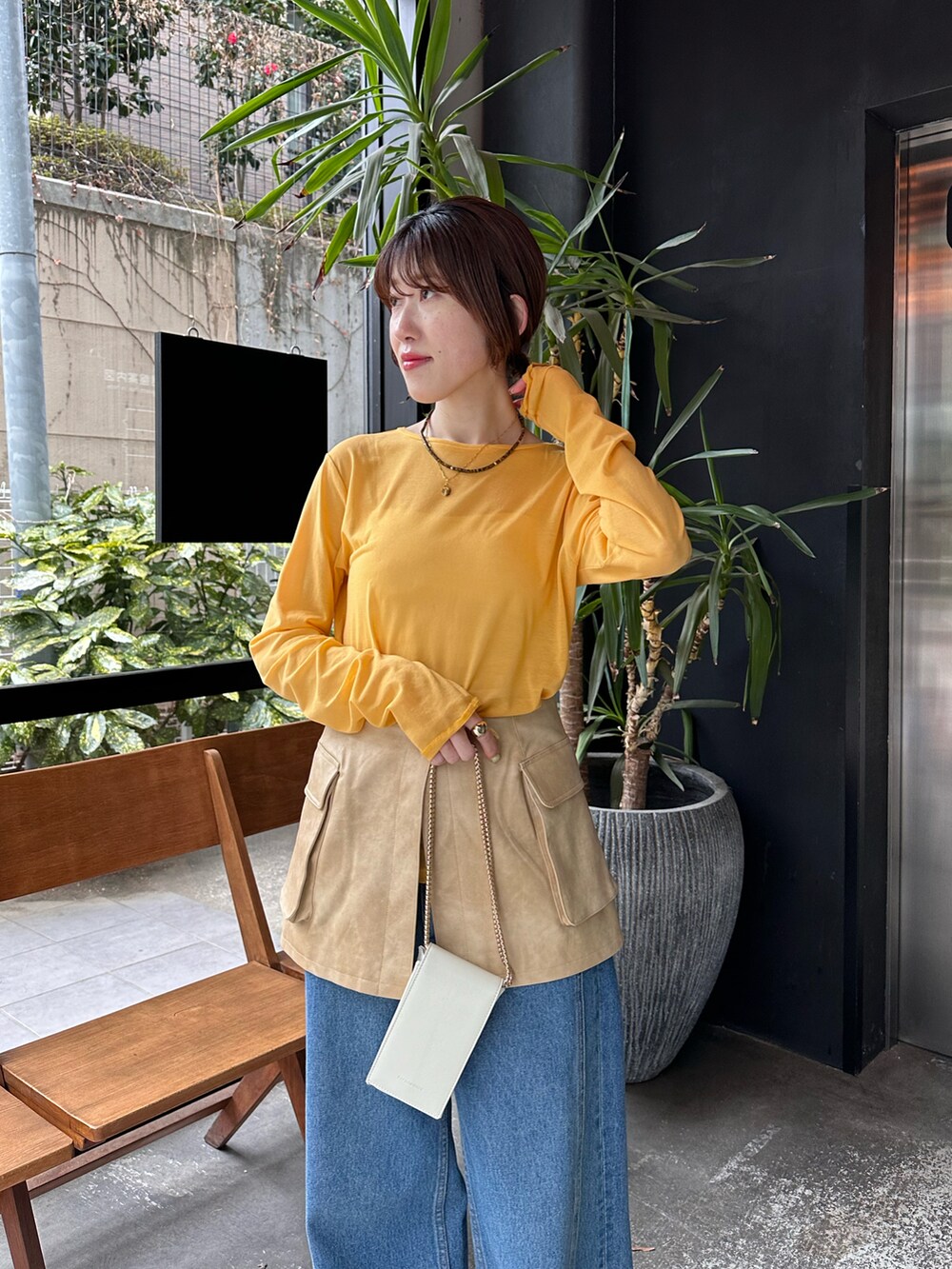 イエロー系のTシャツ/カットソー、ブラック系のデニムパンツを着用したレディースの春コーディネートの4枚目の写真