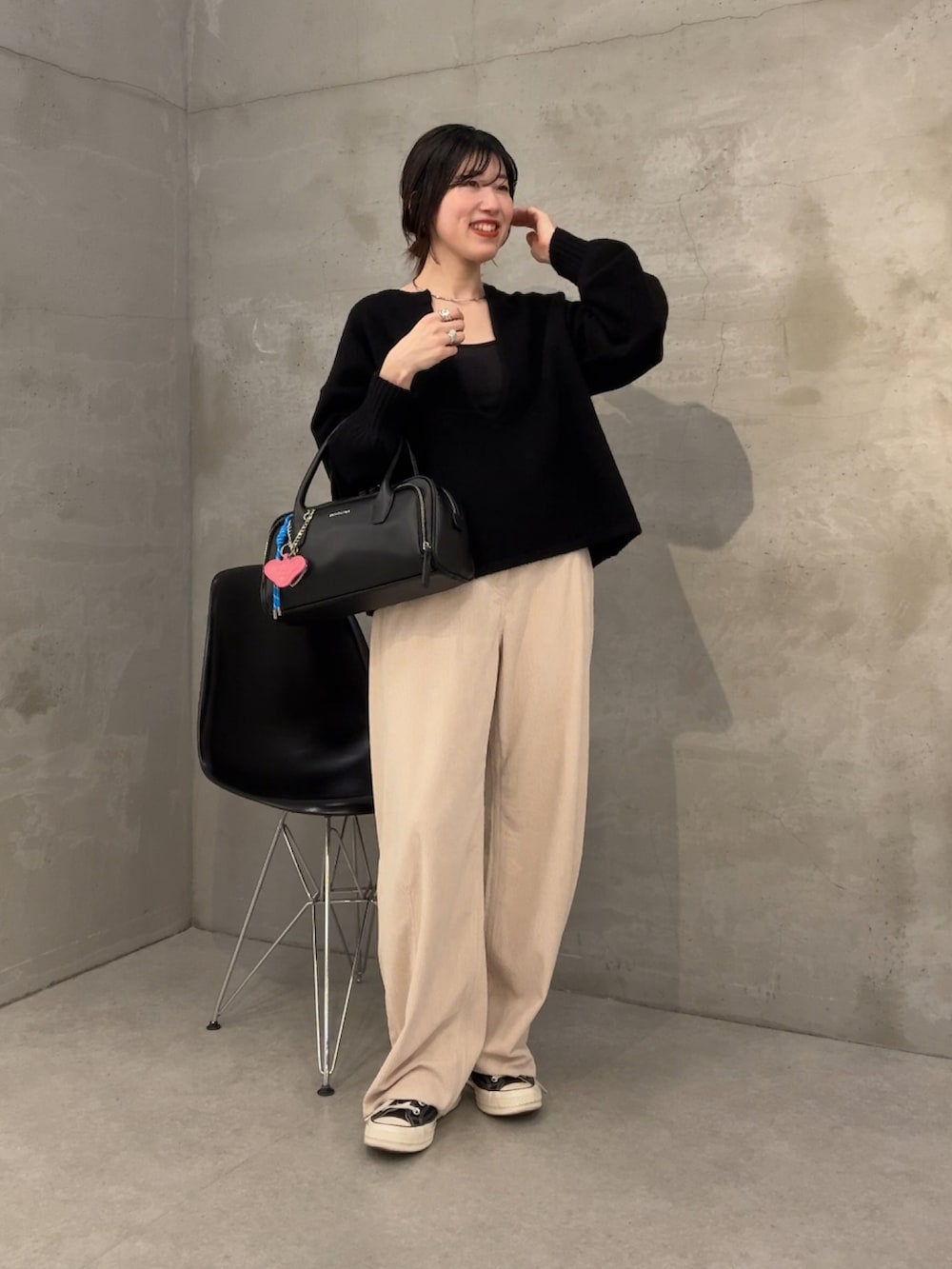 ブラック系のニット/セーター、ホワイト系のデニムパンツを着用したレディースの冬コーディネートの2枚目の写真