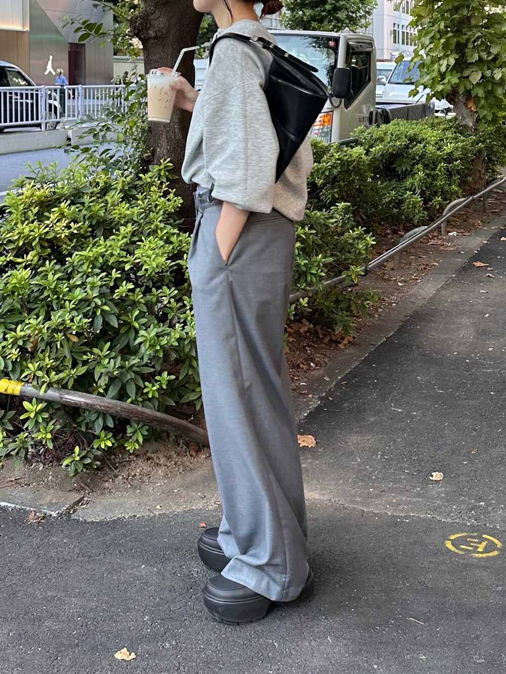 グレー系のニット/セーター、ブラック系のバッグを着用したレディースの秋コーディネートの2枚目の写真