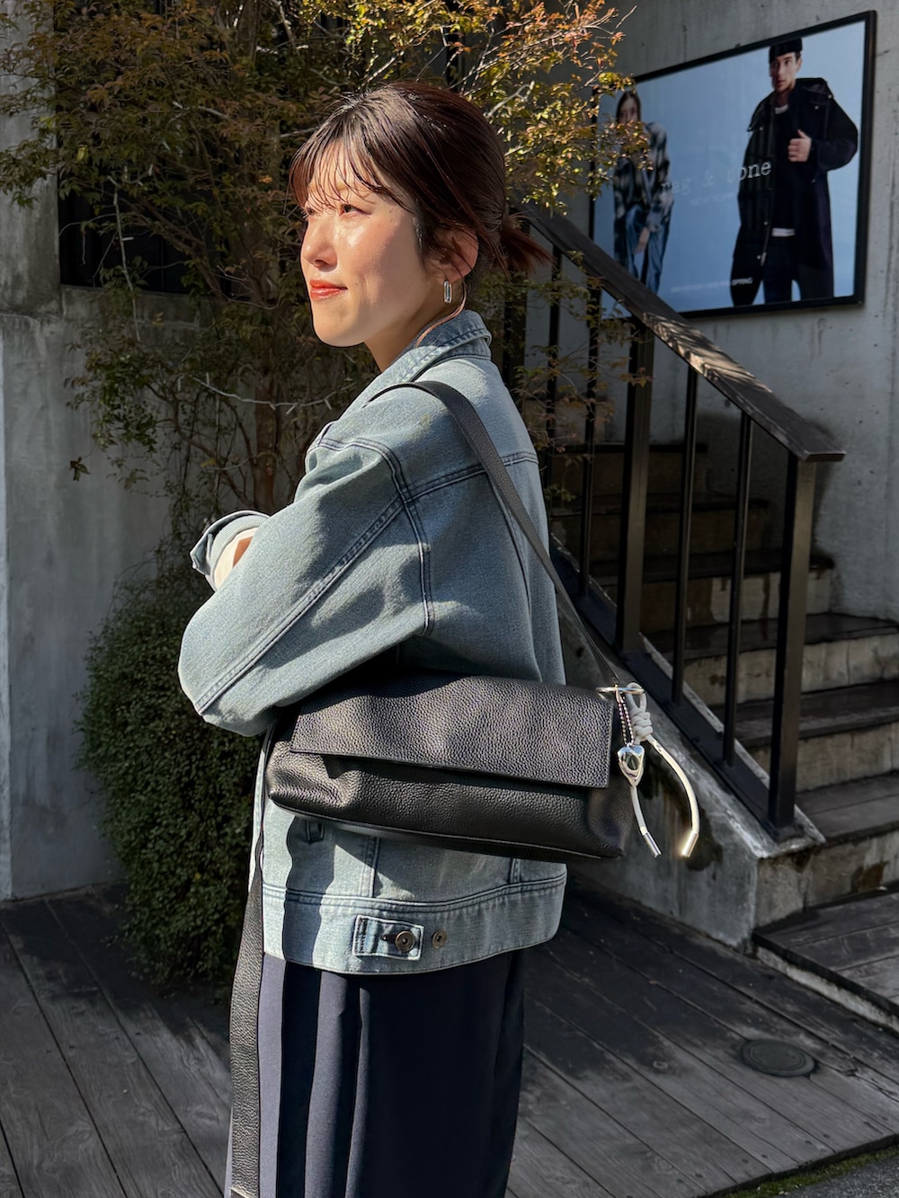 ブルー系のデニムジャケット、ブルー系のその他パンツ、ブラック系のショルダーバッグを着用したレディースの冬コーディネートの3枚目の写真