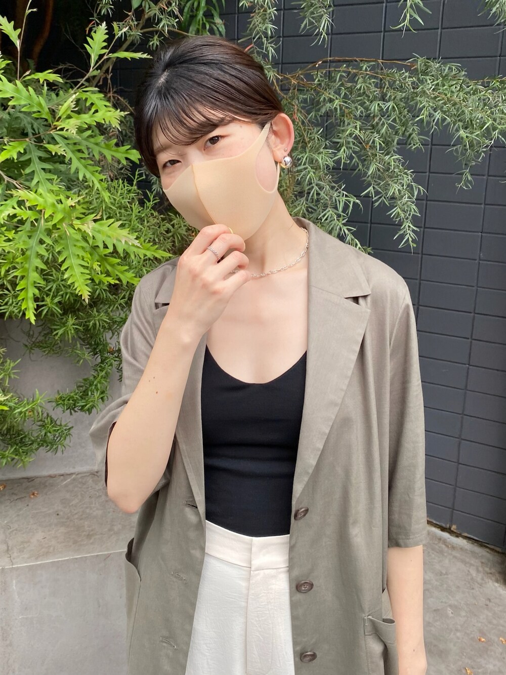 グリーン系のシャツ/ブラウス、ホワイト系のスラックス、ブラック系のショルダーバッグを着用したレディースの夏コーディネートの3枚目の写真