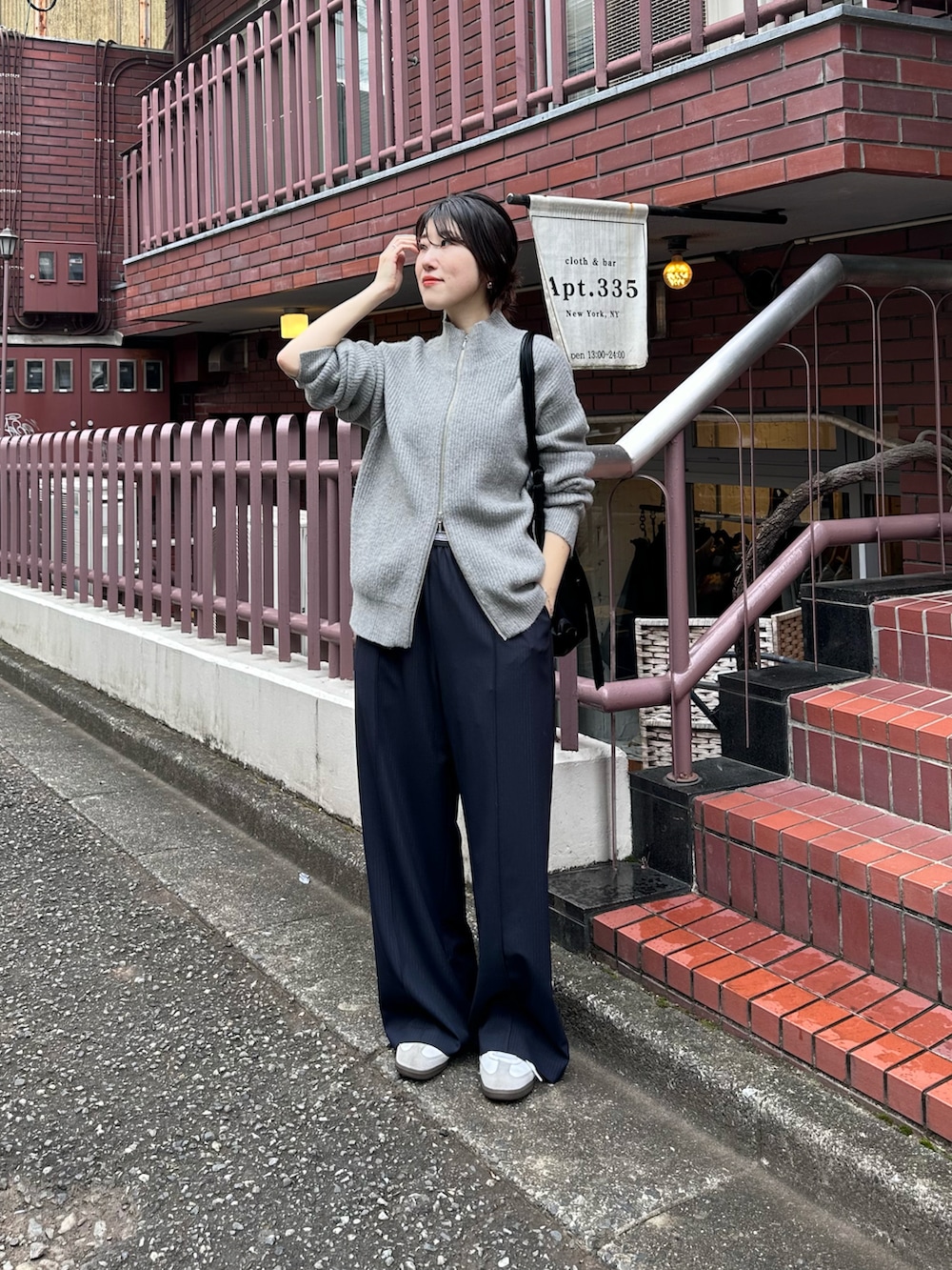 グレー系のカーディガン/ボレロ、ブルー系のスラックス、ブラック系のショルダーバッグを着用したレディースの秋コーディネートの5枚目の写真
