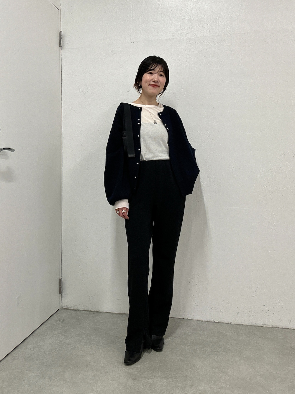 ホワイト系のTシャツ/カットソー、グレー系のニット/セーター、ブラック系のその他パンツを着用したレディースの秋コーディネートの5枚目の写真