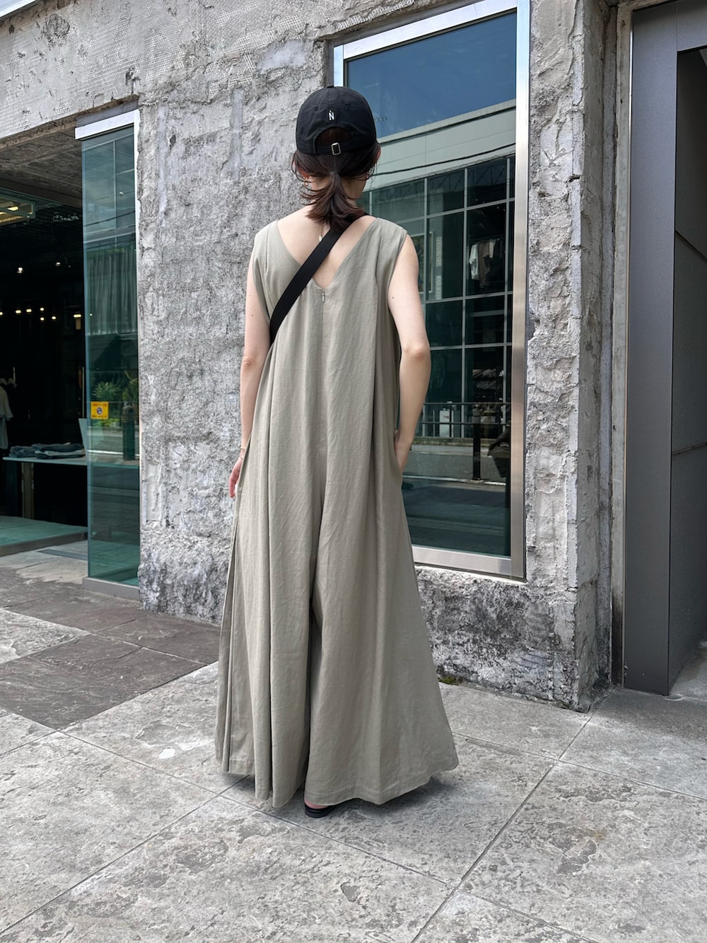 ブラック系のボディバッグ/ウエストポーチ、ブラック系のサンダル、ベージュ系のつなぎ/オールインワンを着用したレディースの春コーディネートの3枚目の写真