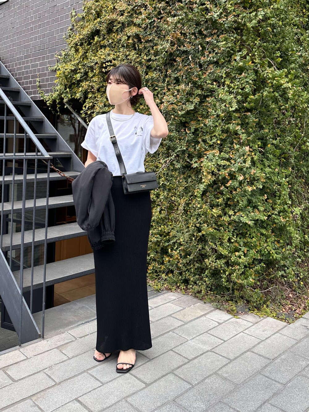ホワイト系のTシャツ/カットソー、ブラック系のスカート、ブラック系のブルゾンを着用したレディースの春コーディネートの3枚目の写真