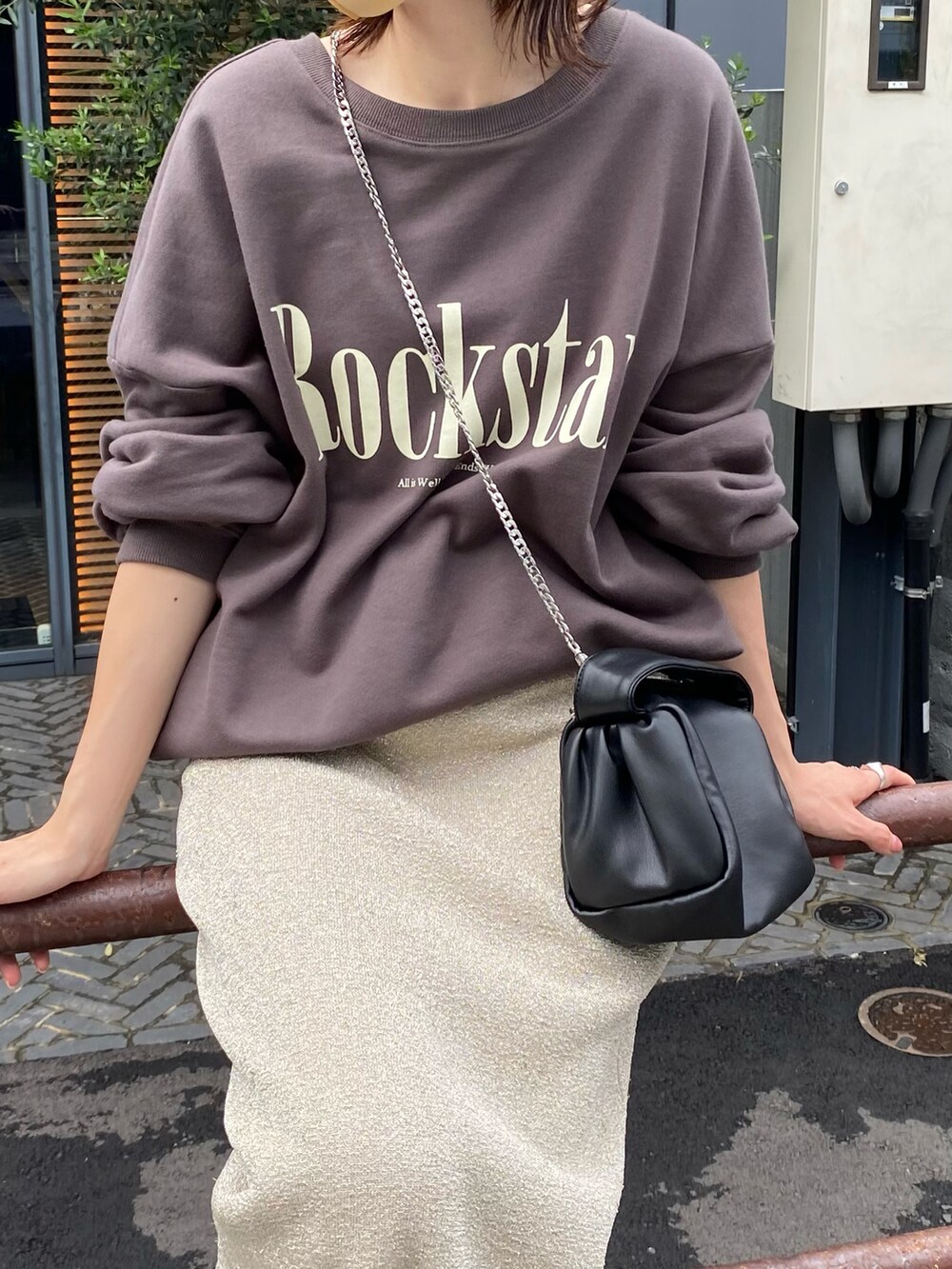 グレー系のスウェット、ゴールド系のスカート、ブラック系のショルダーバッグを着用したレディースの夏コーディネートの2枚目の写真