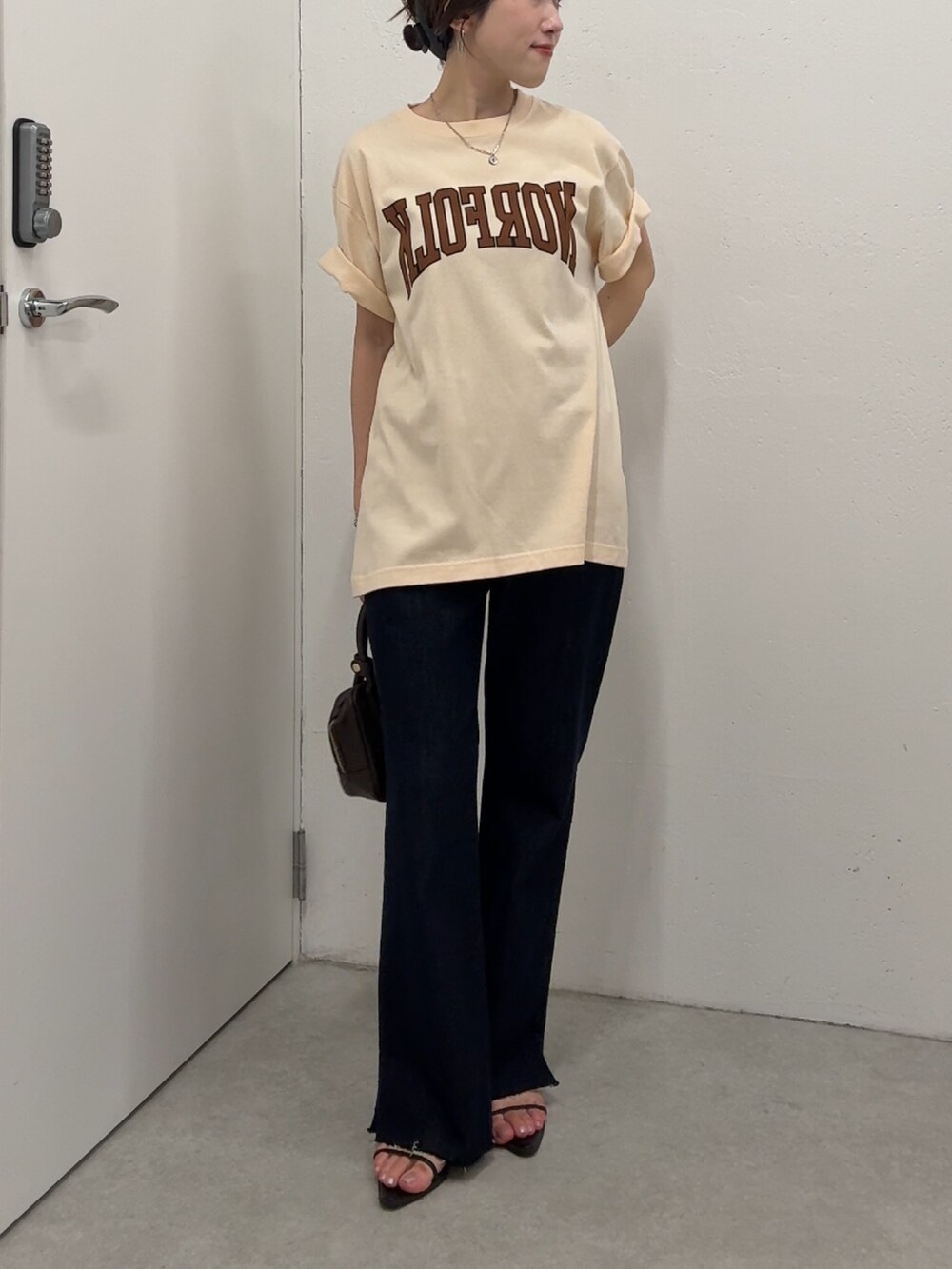 ベージュ系のTシャツ/カットソー、ブルー系のデニムパンツ、ブラウン系のショルダーバッグを着用したレディースの夏コーディネートの5枚目の写真