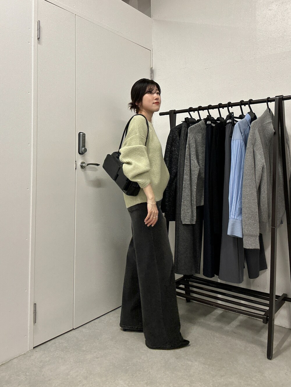 グリーン系のニット/セーター、ブラック系のデニムパンツ、シルバー系のネックレスを着用したレディースの秋コーディネートの2枚目の写真