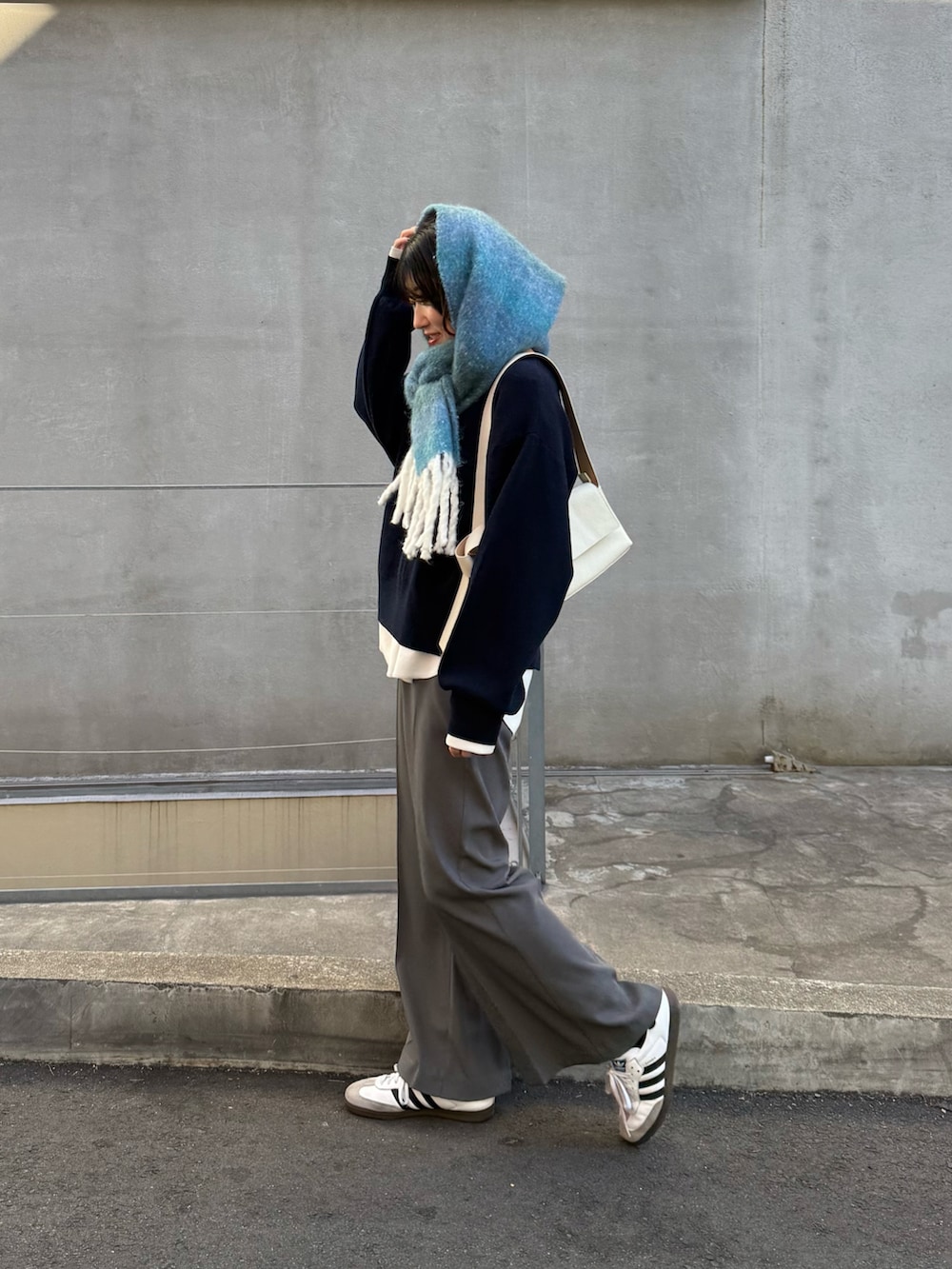 ブルー系のニット/セーター、グレー系のその他パンツ、ホワイト系のTシャツ/カットソーを着用したレディースの冬コーディネートの5枚目の写真