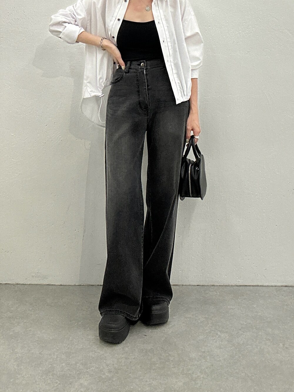 ホワイト系のシャツ/ブラウス、ブラック系のデニムパンツ、ブラック系のハンドバッグを着用したレディースの秋コーディネートの3枚目の写真