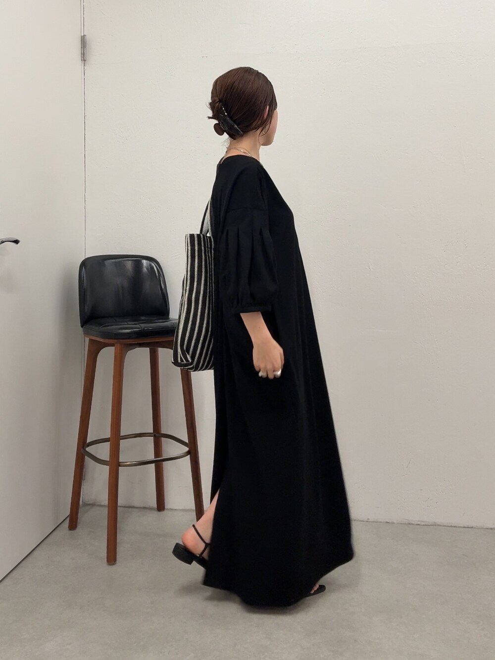 ブラック系のワンピース、ブラック系のトートバッグを着用したレディースの春コーディネートの3枚目の写真