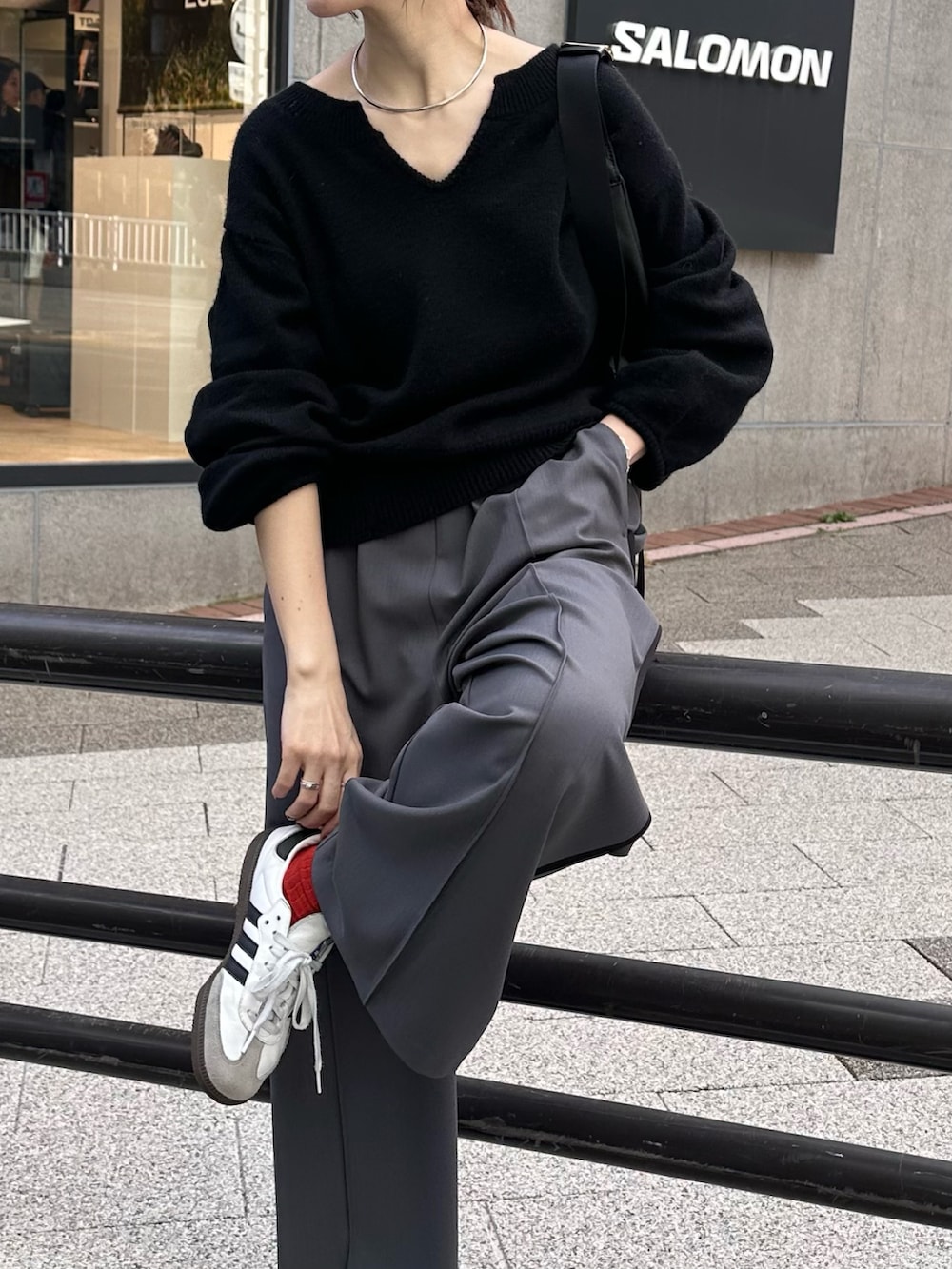 ブラック系のニット/セーター、ブルー系のスラックスを着用したレディースの秋コーディネートの4枚目の写真