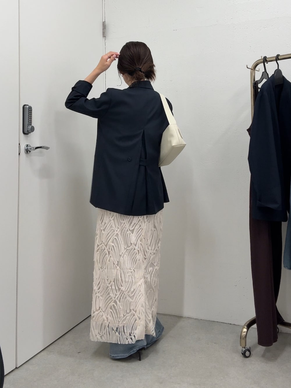 ブルー系のテーラードジャケット、ホワイト系のワンピース/ドレス、ホワイト系のバッグを着用したレディースの春コーディネートの2枚目の写真