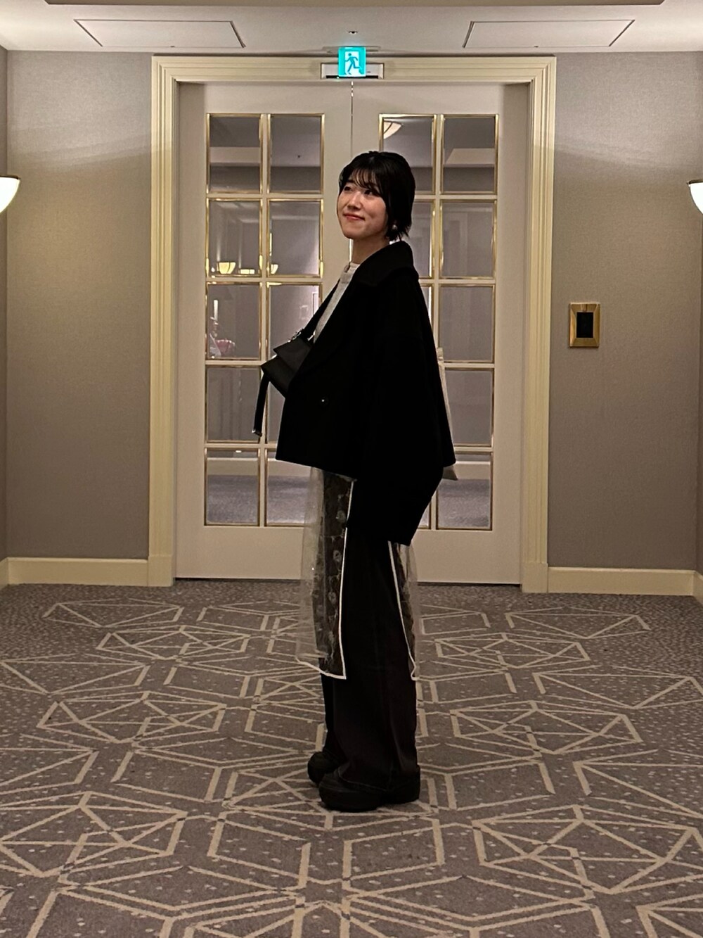 グレー系のニット/セーター、ホワイト系のワンピース、ブルー系のデニムパンツを着用したレディースの冬コーディネートの3枚目の写真