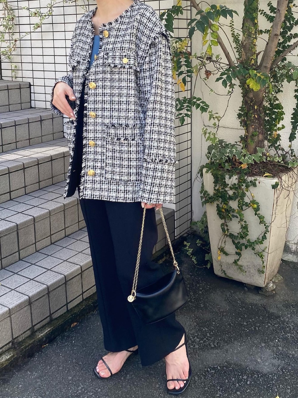 ブルー系のスラックス、ブラック系のノーカラージャケット、ブルー系のタンクトップを着用したレディースの秋コーディネートの3枚目の写真