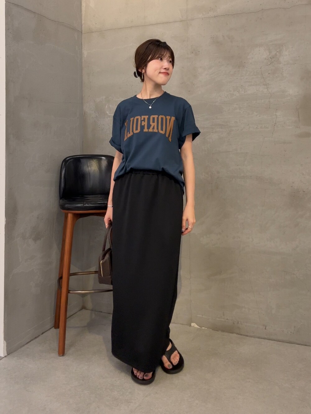 ブルー系のTシャツ/カットソー、ブラック系のスカート、ブラウン系のショルダーバッグを着用したレディースの夏コーディネートの4枚目の写真