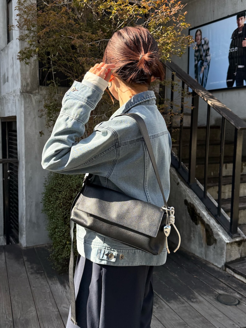 ブルー系のデニムジャケット、ブルー系のその他パンツ、ブラック系のショルダーバッグを着用したレディースの冬コーディネートの4枚目の写真