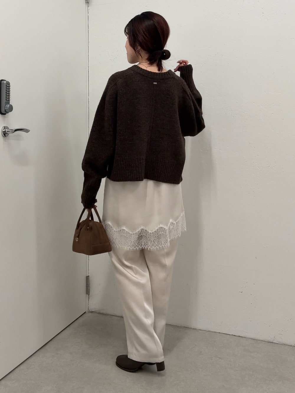 ブラウン系のニット/セーター、ホワイト系のその他パンツ、ブラウン系のボストンバッグを着用したレディースの秋コーディネートの2枚目の写真