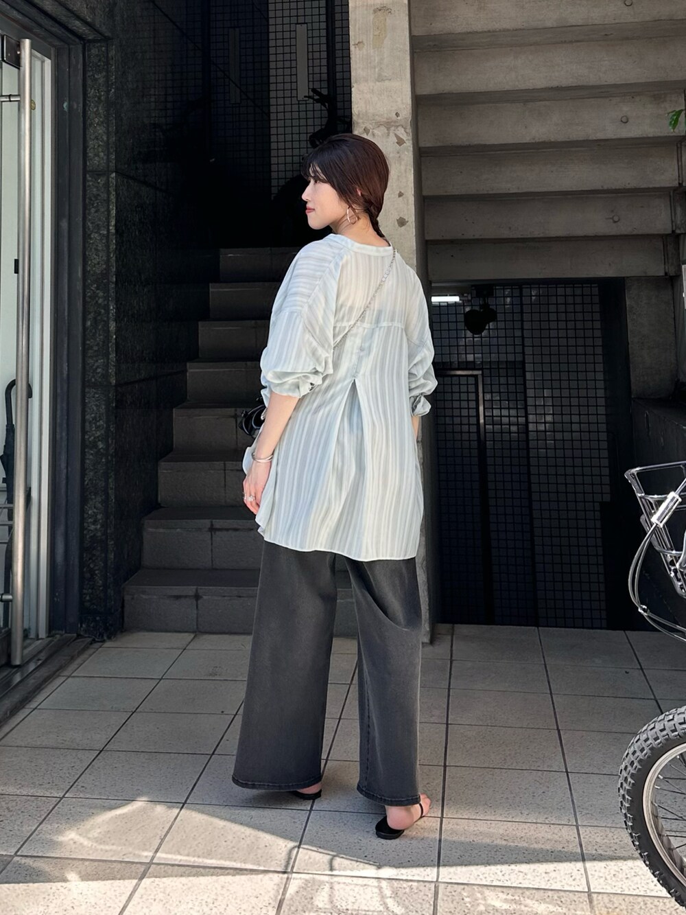 グリーン系のシャツ/ブラウス、ブラック系のデニムパンツ、ブラック系のショルダーバッグを着用したレディースの夏コーディネートの2枚目の写真