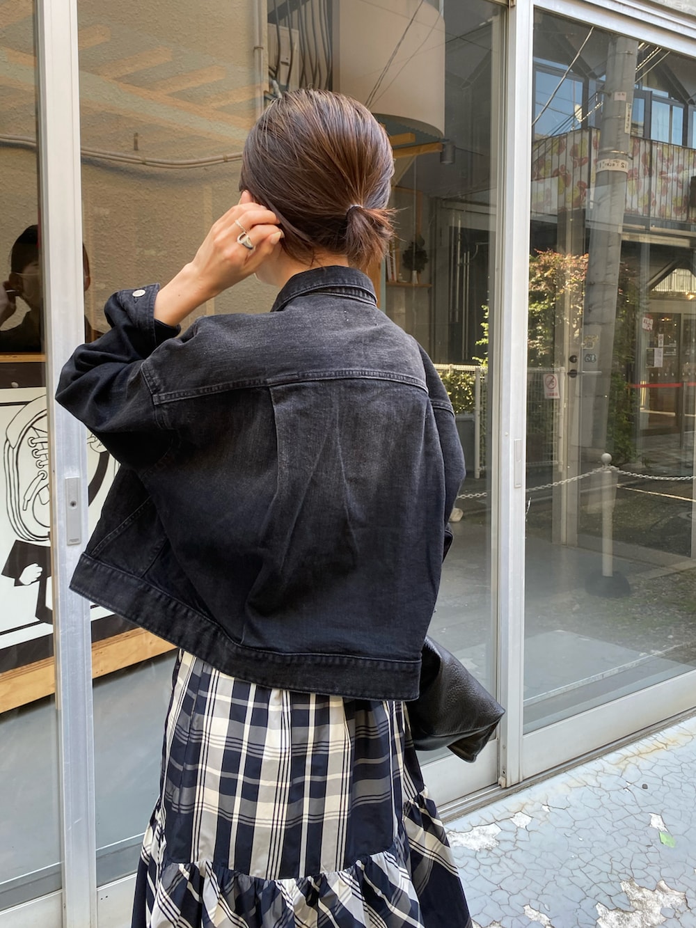 ブラック系のトートバッグ、ブラック系のスカート、ブラック系のデニムジャケットを着用したレディースの秋コーディネートの4枚目の写真