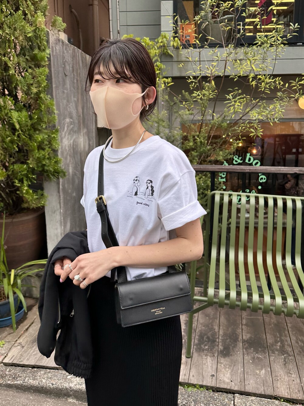 ホワイト系のTシャツ/カットソー、ブラック系のスカート、ブラック系のブルゾンを着用したレディースの春コーディネートの4枚目の写真