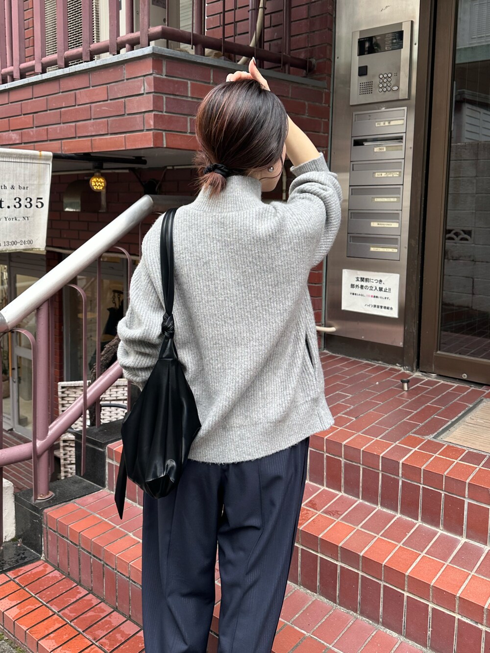 グレー系のカーディガン/ボレロ、ブルー系のスラックス、ブラック系のショルダーバッグを着用したレディースの秋コーディネートの4枚目の写真
