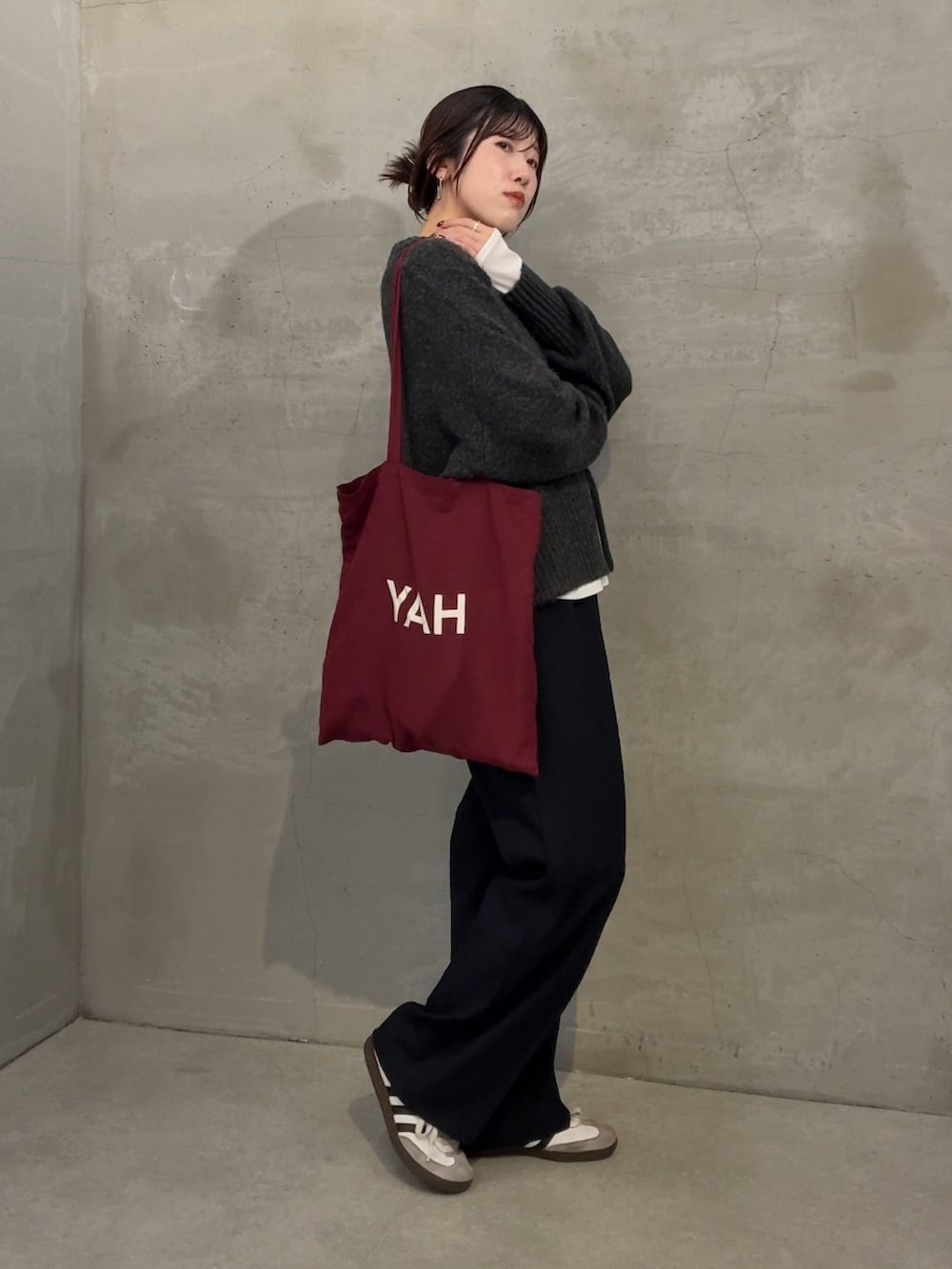 グレー系のニット/セーター、ホワイト系のTシャツ/カットソー、ブルー系のスラックスを着用したレディースの冬コーディネートの3枚目の写真