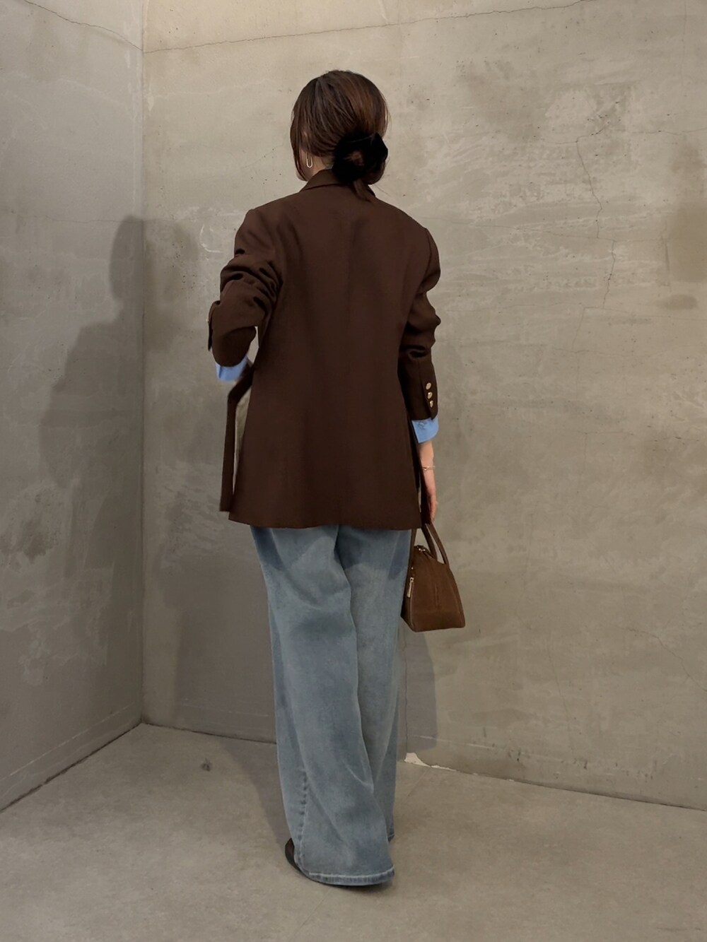ブラウン系のテーラードジャケット、ブルー系のシャツ/ブラウス、ブルー系のデニムパンツを着用したレディースの秋コーディネートの3枚目の写真