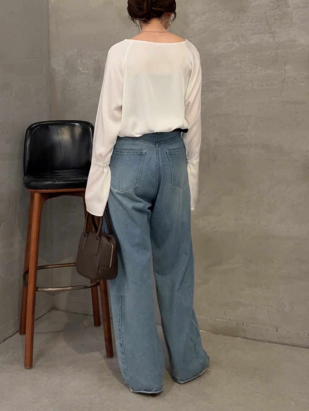 ブルー系のデニムパンツ、ホワイト系のシャツ/ブラウス、ブラウン系のショルダーバッグを着用したレディースの夏コーディネートの3枚目の写真