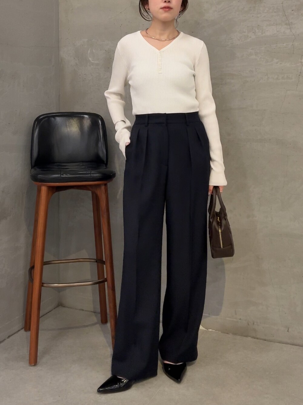 ホワイト系のニット/セーター、ブラウン系のショルダーバッグ、ブルー系のスラックスを着用したレディースの夏コーディネートの4枚目の写真