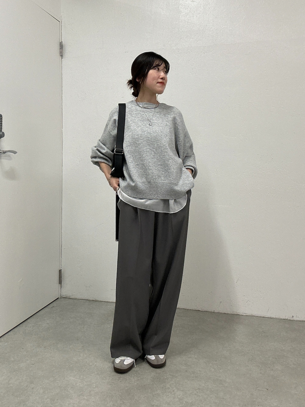 グレー系のニット/セーター、ホワイト系のTシャツ/カットソー、グレー系のその他パンツを着用したレディースの冬コーディネートの5枚目の写真