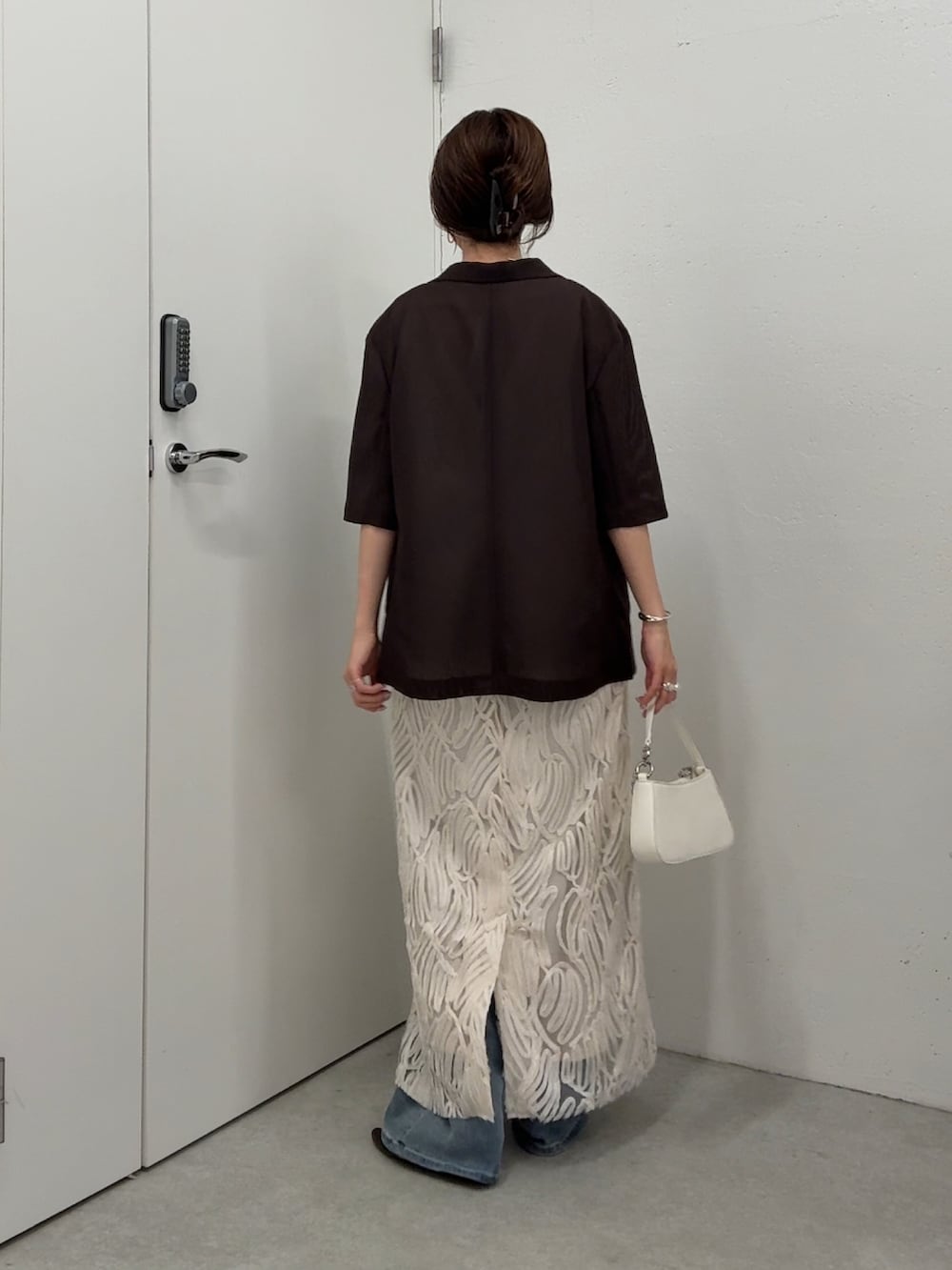 ホワイト系のワンピース、ブラウン系のテーラードジャケット、ホワイト系のショルダーバッグを着用したレディースの春コーディネートの4枚目の写真