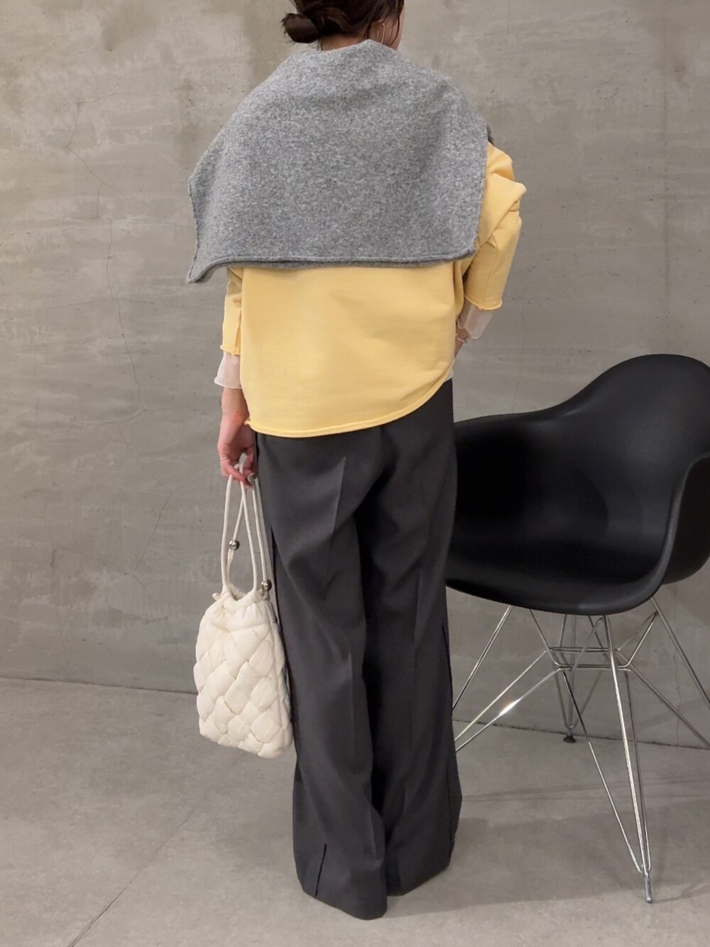 イエロー系のスウェット、ホワイト系のTシャツ/カットソー、グレー系のスラックスを着用したレディースの秋コーディネートの3枚目の写真