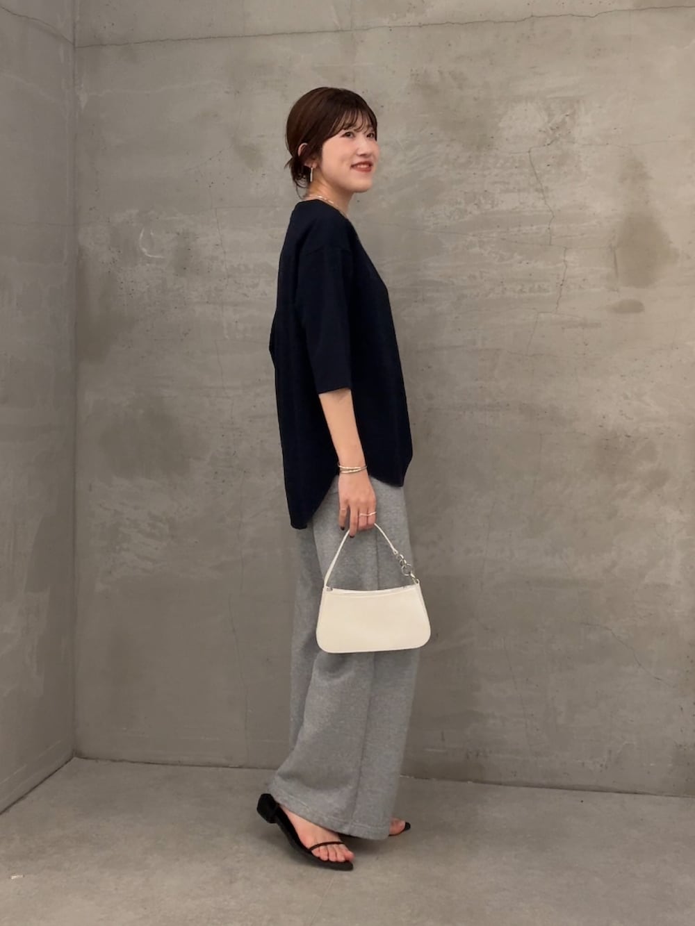 ブルー系のTシャツ/カットソー、グレー系のデニムパンツ、ホワイト系のショルダーバッグを着用したレディースの春コーディネートの2枚目の写真