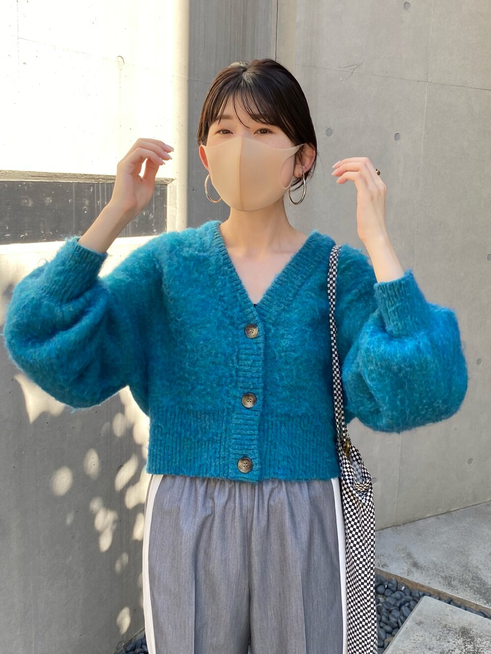 ブルー系のカーディガン/ボレロ、グレー系のスラックスを着用したレディースの秋コーディネートの4枚目の写真