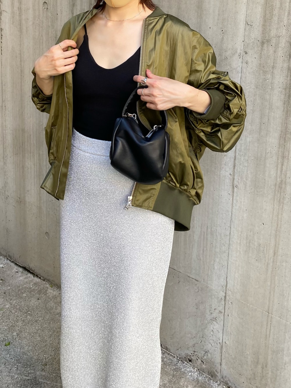 グリーン系のMA-1、ブラック系のキャミソール、ブラック系のショルダーバッグを着用したレディースの夏コーディネートの3枚目の写真