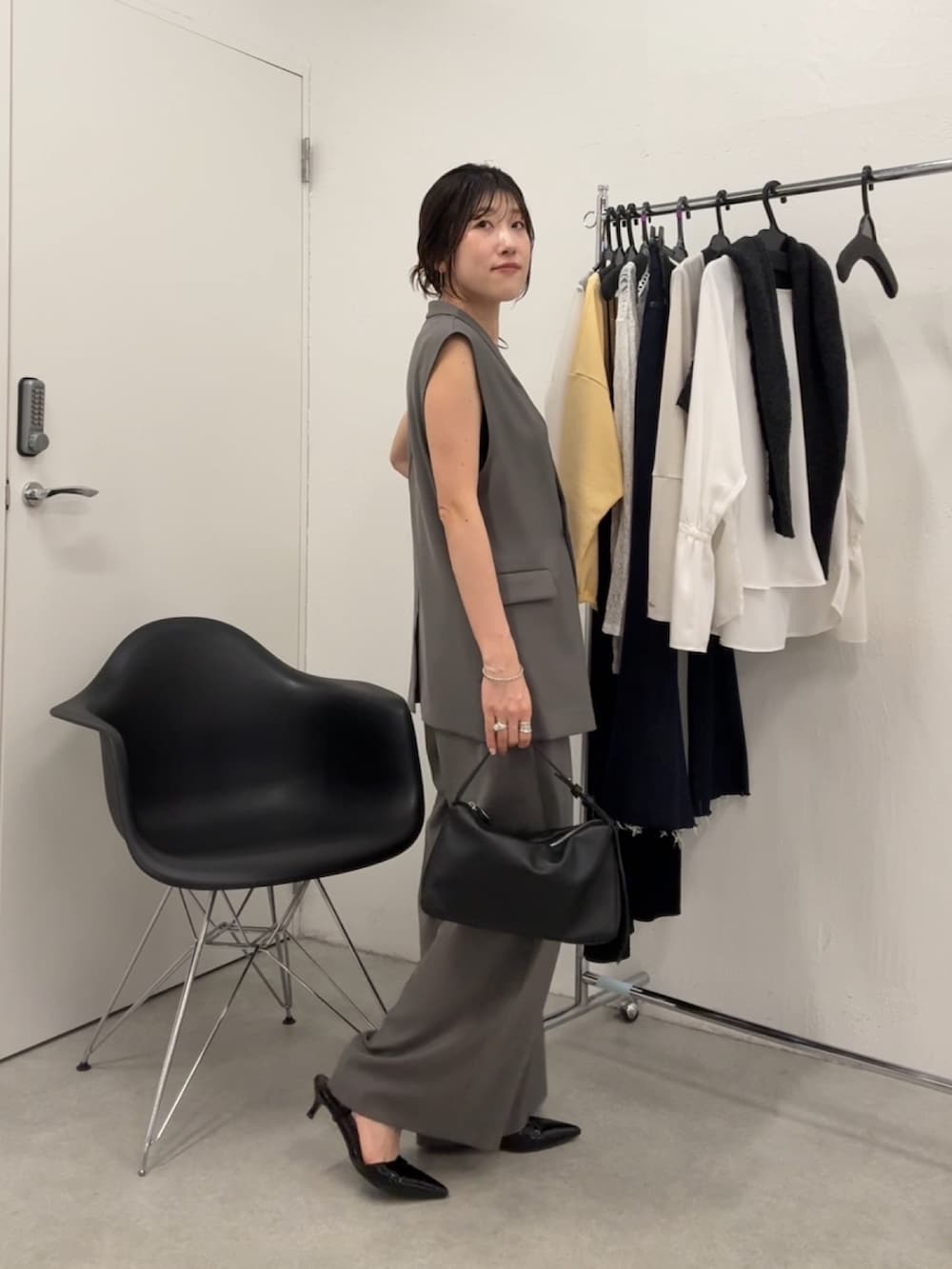 グレー系のセットアップ、ブラック系のパンプスを着用したレディースの秋コーディネートの2枚目の写真