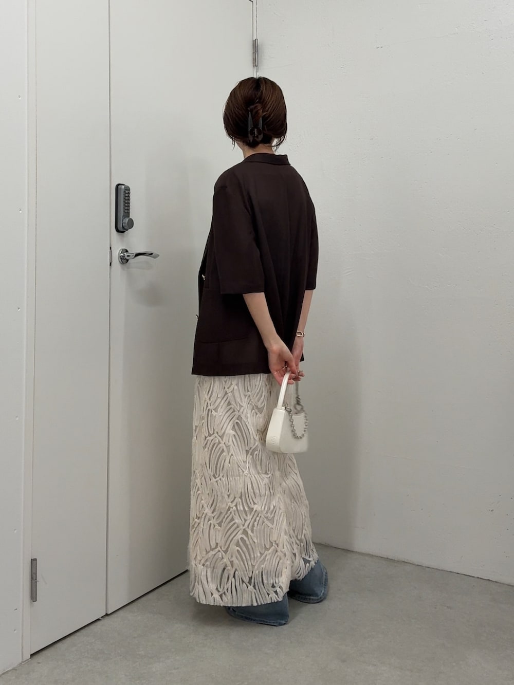 ホワイト系のワンピース、ブラウン系のテーラードジャケット、ホワイト系のショルダーバッグを着用したレディースの春コーディネートの3枚目の写真