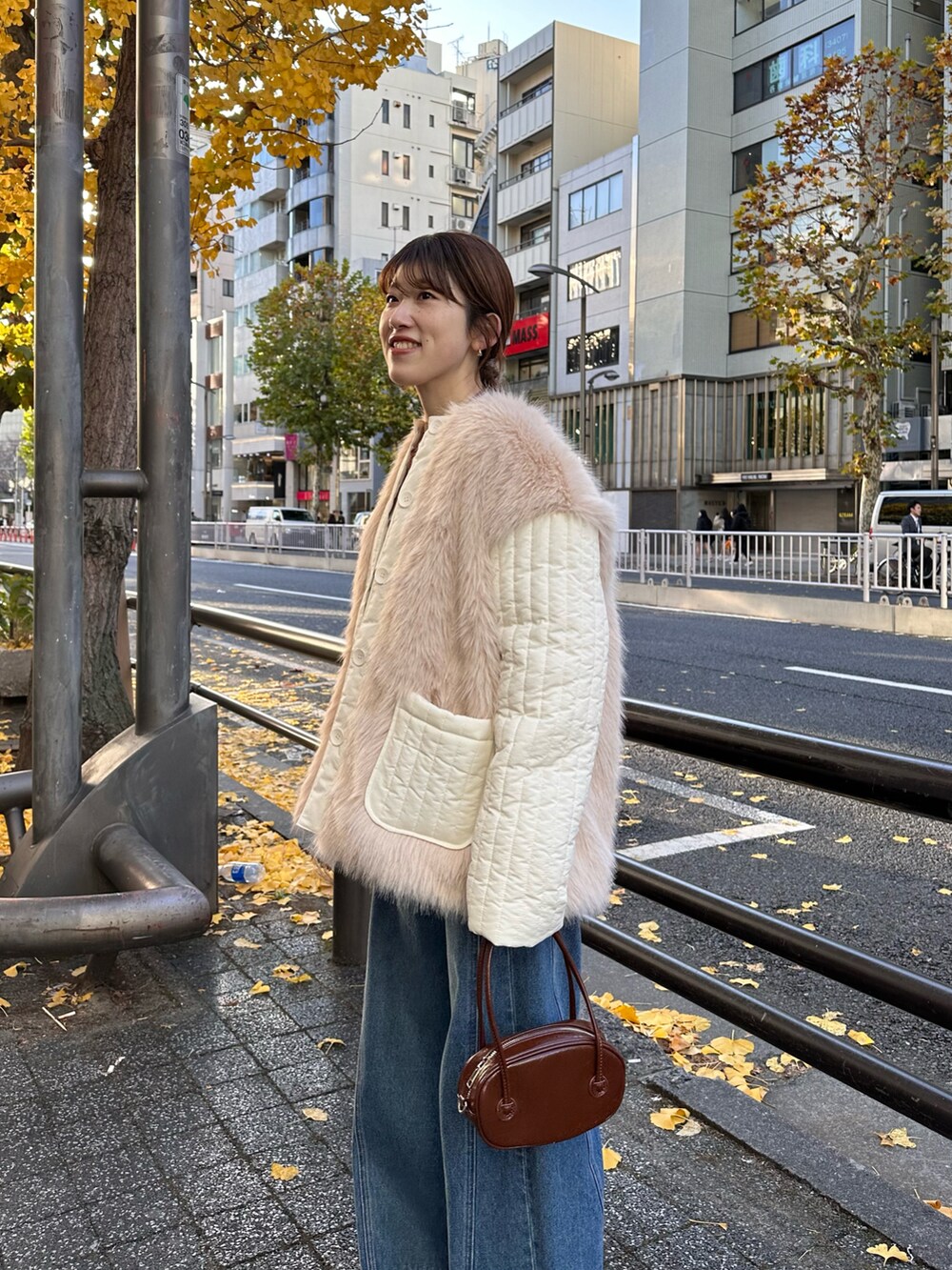 ブラウン系のハンドバッグ、ホワイト系のダウンジャケット/コート、グレー系のスウェットを着用したレディースの冬コーディネートの2枚目の写真
