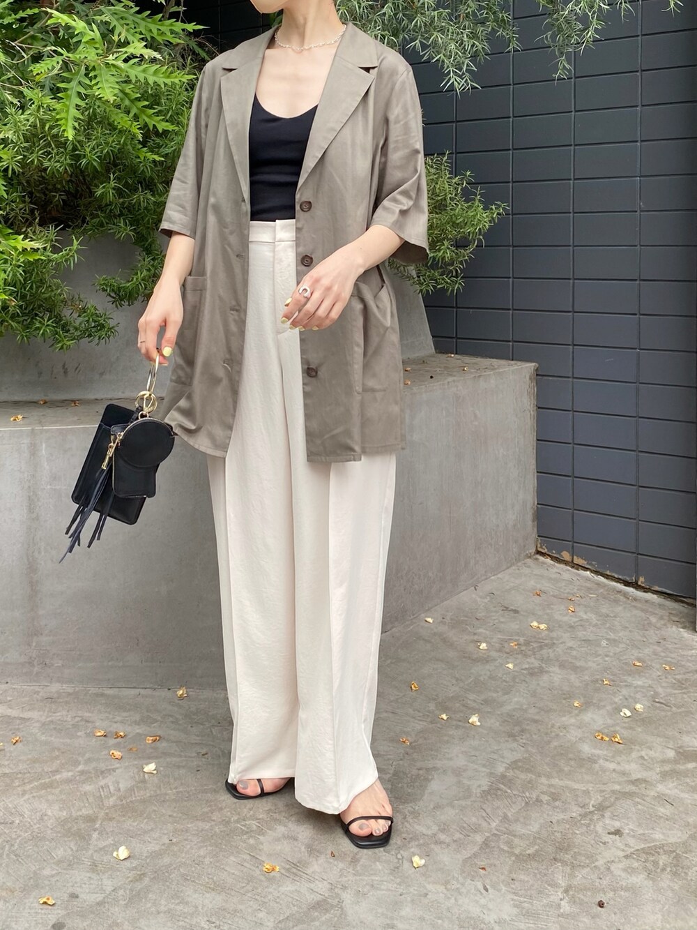 グリーン系のシャツ/ブラウス、ホワイト系のスラックス、ブラック系のショルダーバッグを着用したレディースの夏コーディネートの2枚目の写真