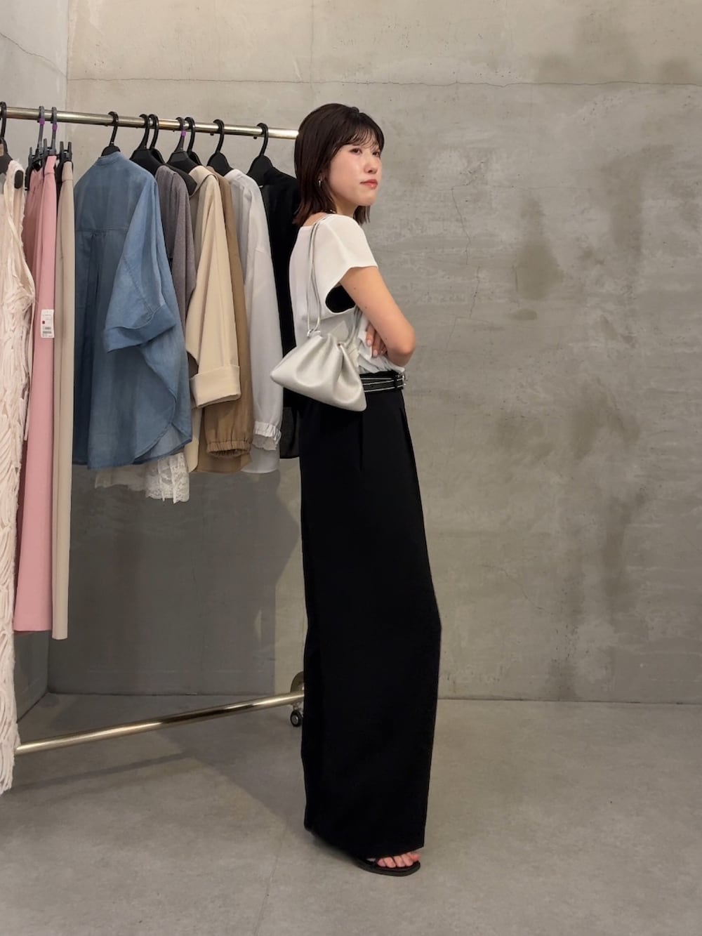 ホワイト系のTシャツ/カットソー、ブラック系のスラックス、シルバー系のネックレスを着用したレディースの春コーディネートの4枚目の写真