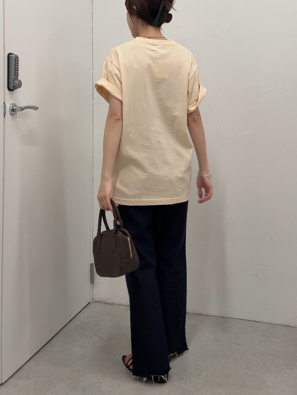 ベージュ系のTシャツ/カットソー、ブルー系のデニムパンツ、ブラウン系のショルダーバッグを着用したレディースの夏コーディネートの3枚目の写真